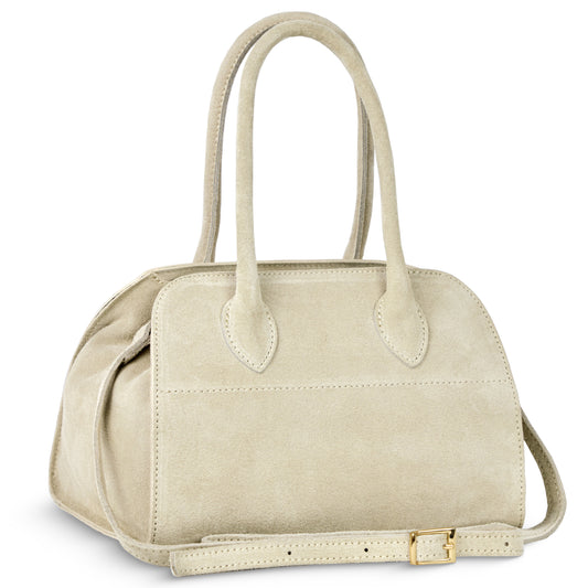 A handmade Italian handbag in beige suede with two handles, a structured rectangular shape, and a detachable strap with a gold buckle, crafted from genuine Florentine leather and set against a white background.