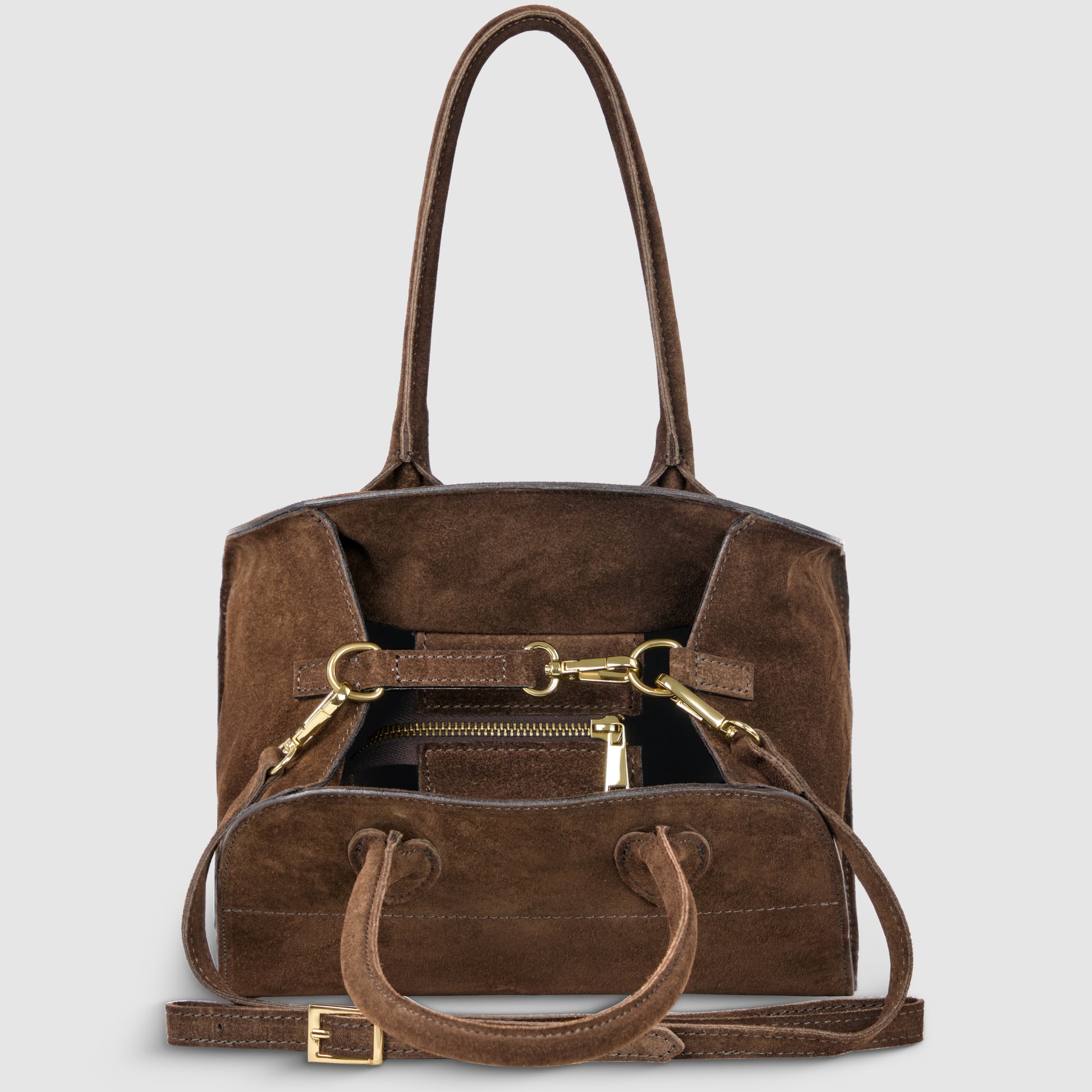 A Handmade Italian handbag in brown genuine suede with gold hardware sits open, showing a zippered pocket inside. Featuring two handles and a detachable shoulder strap with a gold buckle, it's displayed against a light gray background.