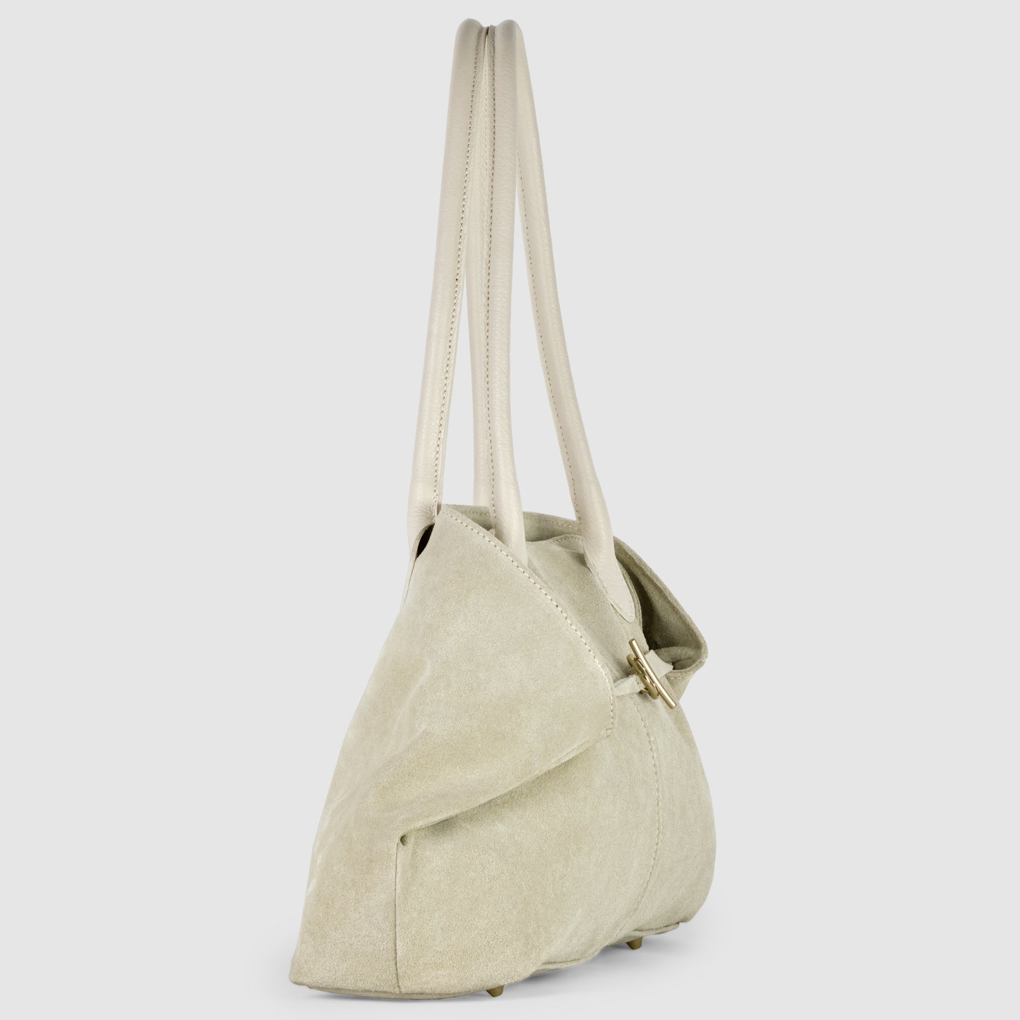 A light beige suede tote bag with two long genuine leather handles, a soft triangular shape, and a gold clasp, shown standing upright against a plain light gray background.