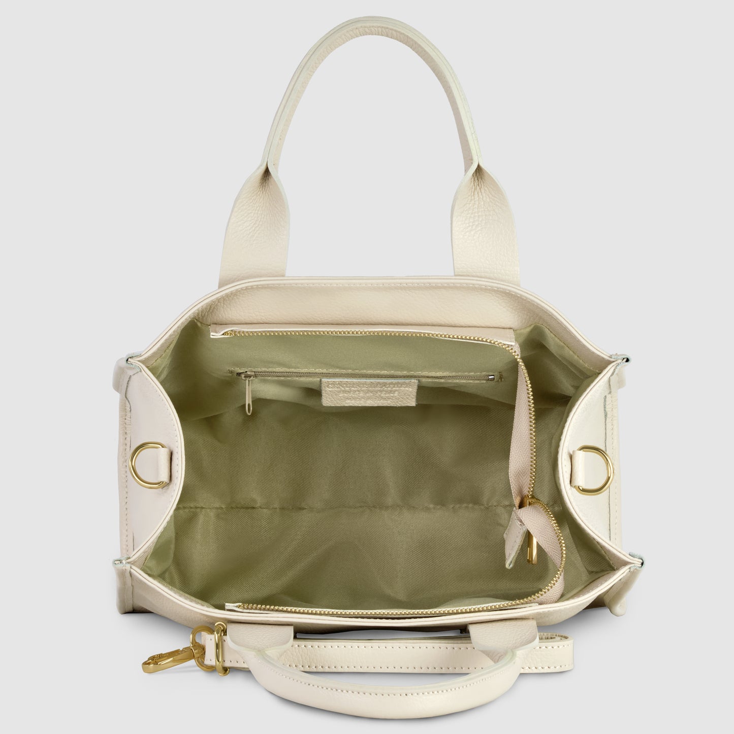 An open cream-colored Italian leather handbag with gold hardware, showing a spacious light green interior, a zippered pocket, an open pocket, and a key strap. The bag has two handles and a top zipper closure.
