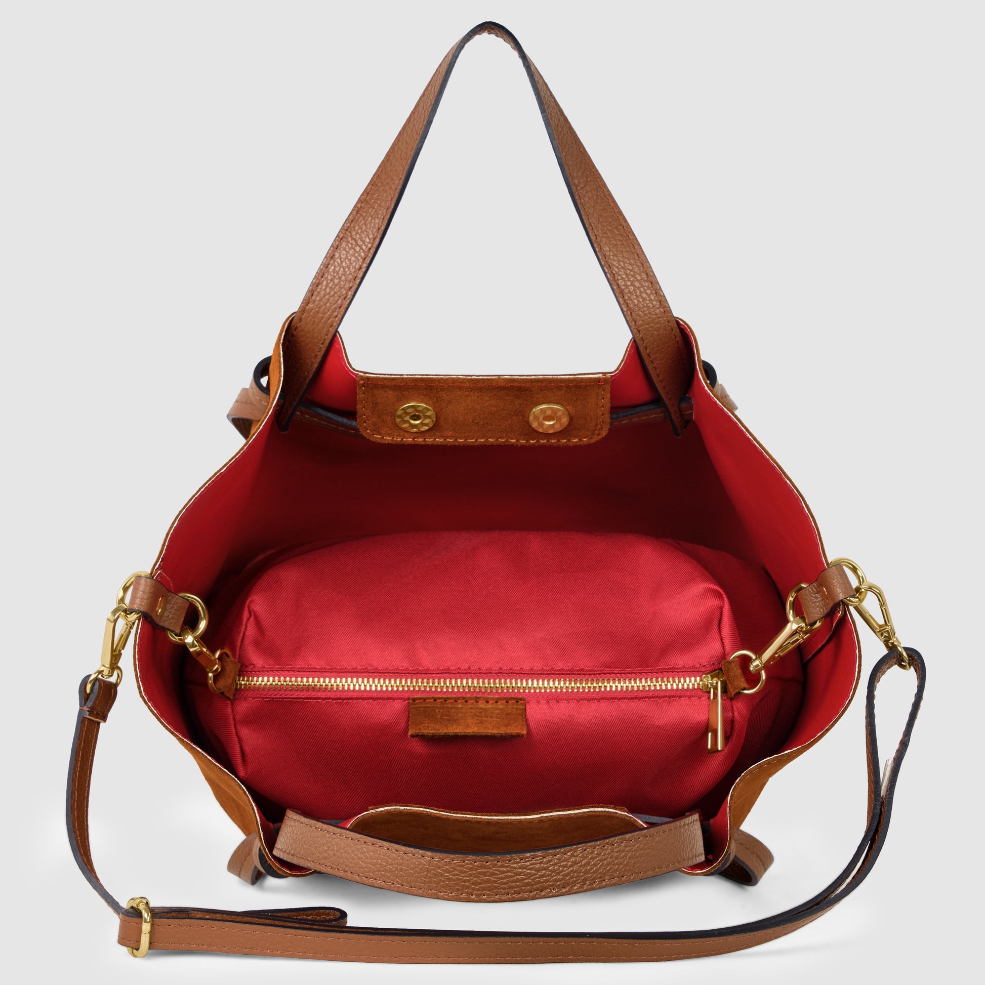 A handmade Italian bag crafted from brown Florentine leather, this shoulder handbag boasts a red interior lining and an inner zippered pouch, displayed open to reveal its spacious, organized compartments.