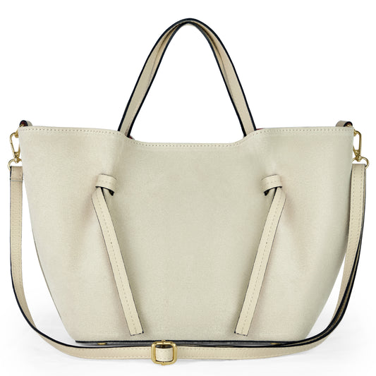 A beige suede tote inspired by Florentine leatherwork, featuring two short handles, front decorative straps, and a long adjustable shoulder strap with gold-tone hardware, displayed against a white background.
