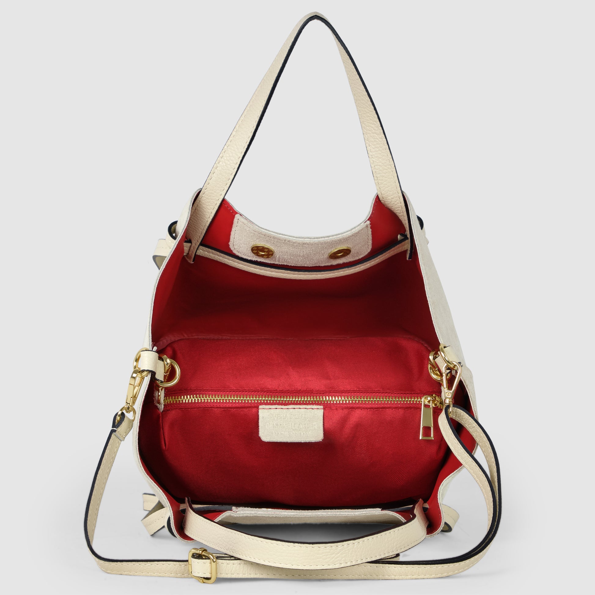 A cream-colored handmade Italian bag with gold hardware and an adjustable shoulder strap, shown open to reveal a bright red interior lining and a zippered pocket—a true showcase of Florentine leatherwork.