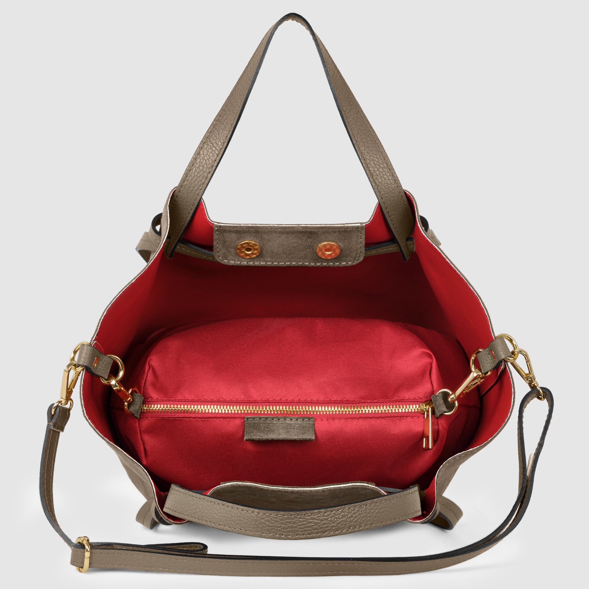 A taupe leather handbag crafted with exquisite Florentine leatherwork, featuring a red interior, gold hardware, and a matching detachable shoulder strap. The open bag reveals a red zippered pouch inside.