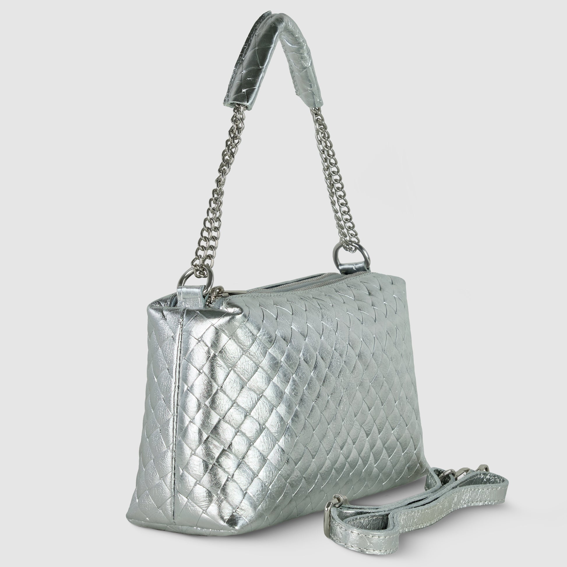 A silver quilted miniature handbag with a chain and leather shoulder strap, shown at an angle. A detachable matching crossbody strap is placed in front of the bag. The background is plain light gray, highlighting its Italian craftsmanship.