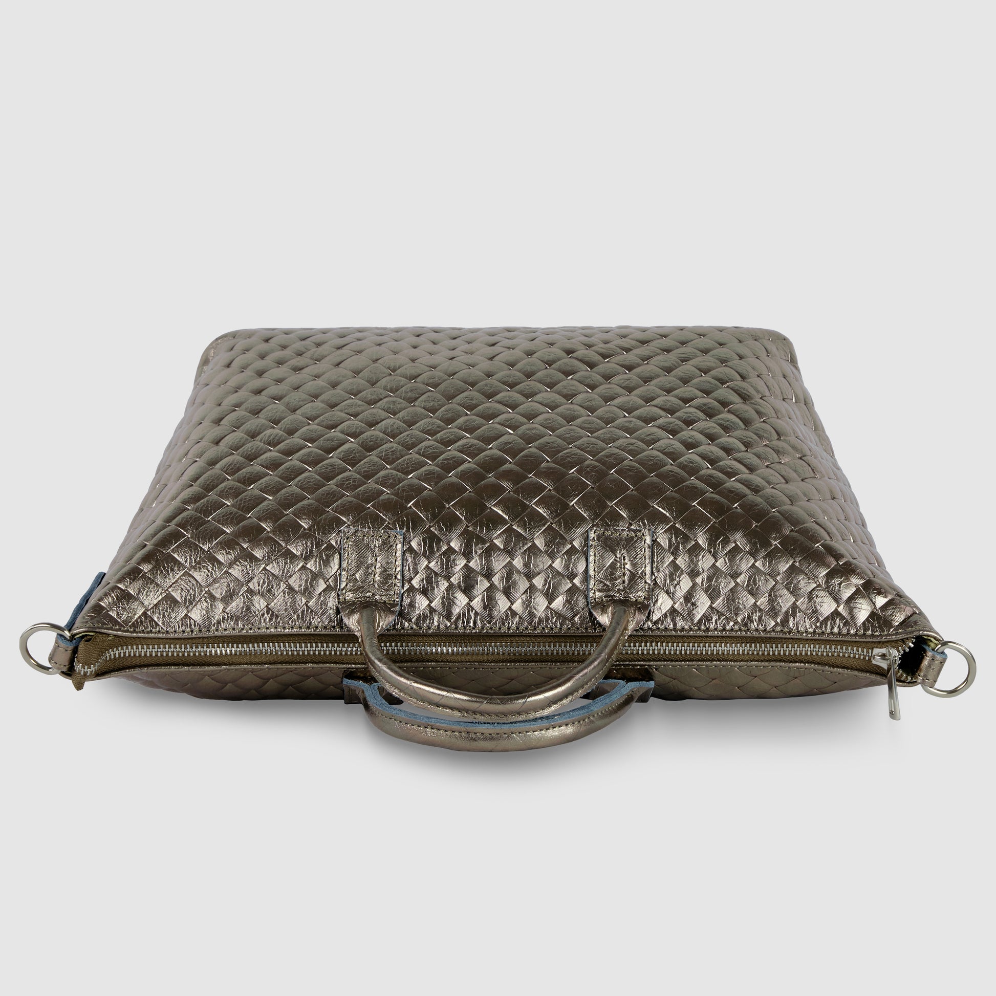 A metallic quilted leather handbag, inspired by Florentine leathercraft, features two handles, a zipper closure, and silver hardware, displayed against a plain light gray background.