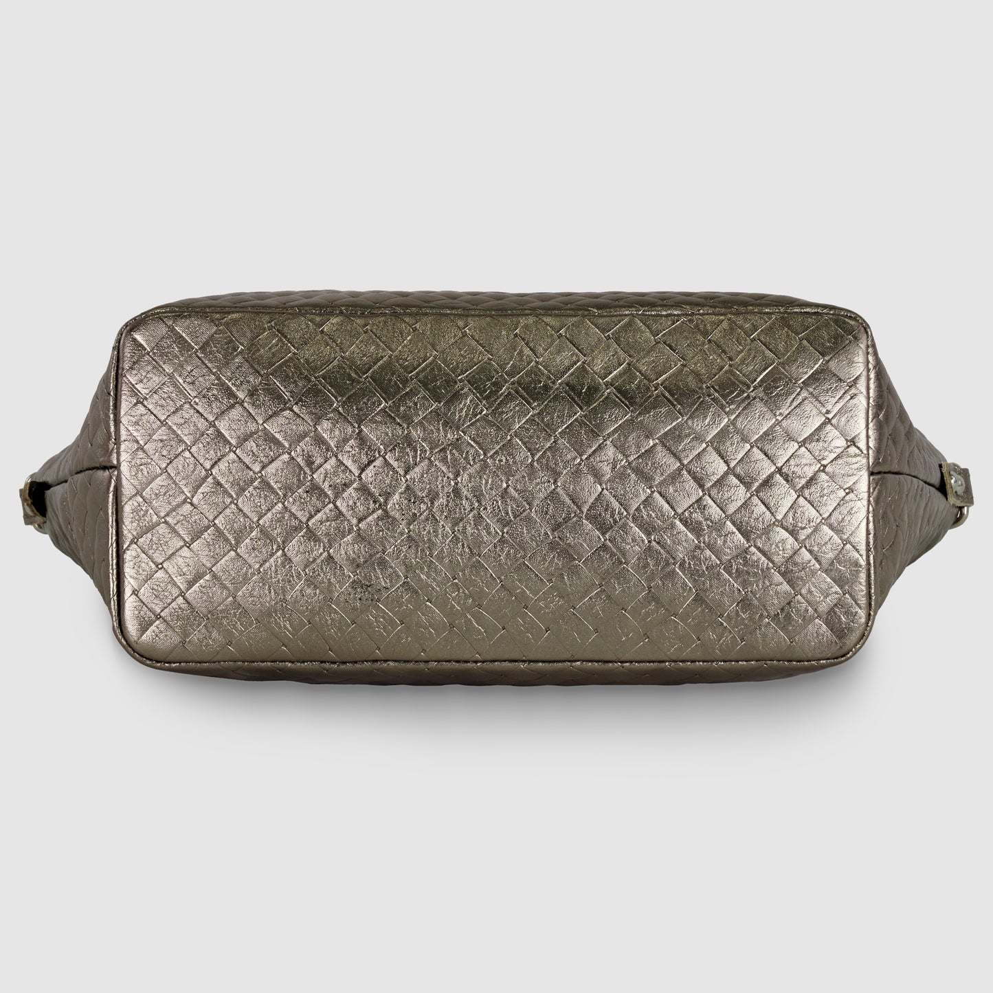 Rectangular, metallic bronze handcrafted Italian handbag with a woven, textured pattern shown from the bottom view, against a plain light background.