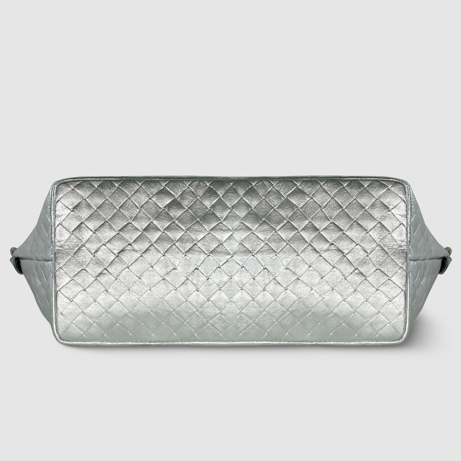 A rectangular silver quilted bag with a diamond-patterned texture, this handcrafted Italian handbag is shown from the bottom against a light gray background.