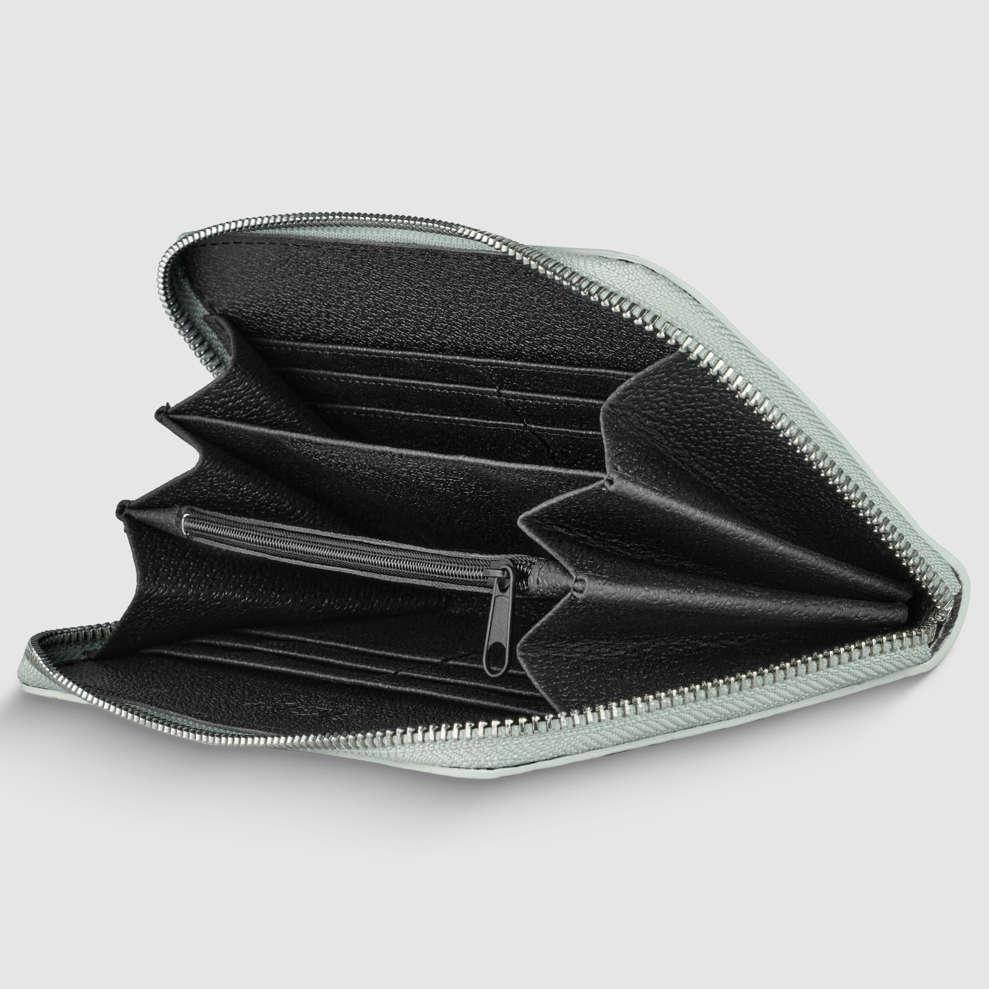 A zippered black Italian leather wallet is open, showing multiple compartments for cards, cash, and a central zippered pocket for coins against a plain light gray background.